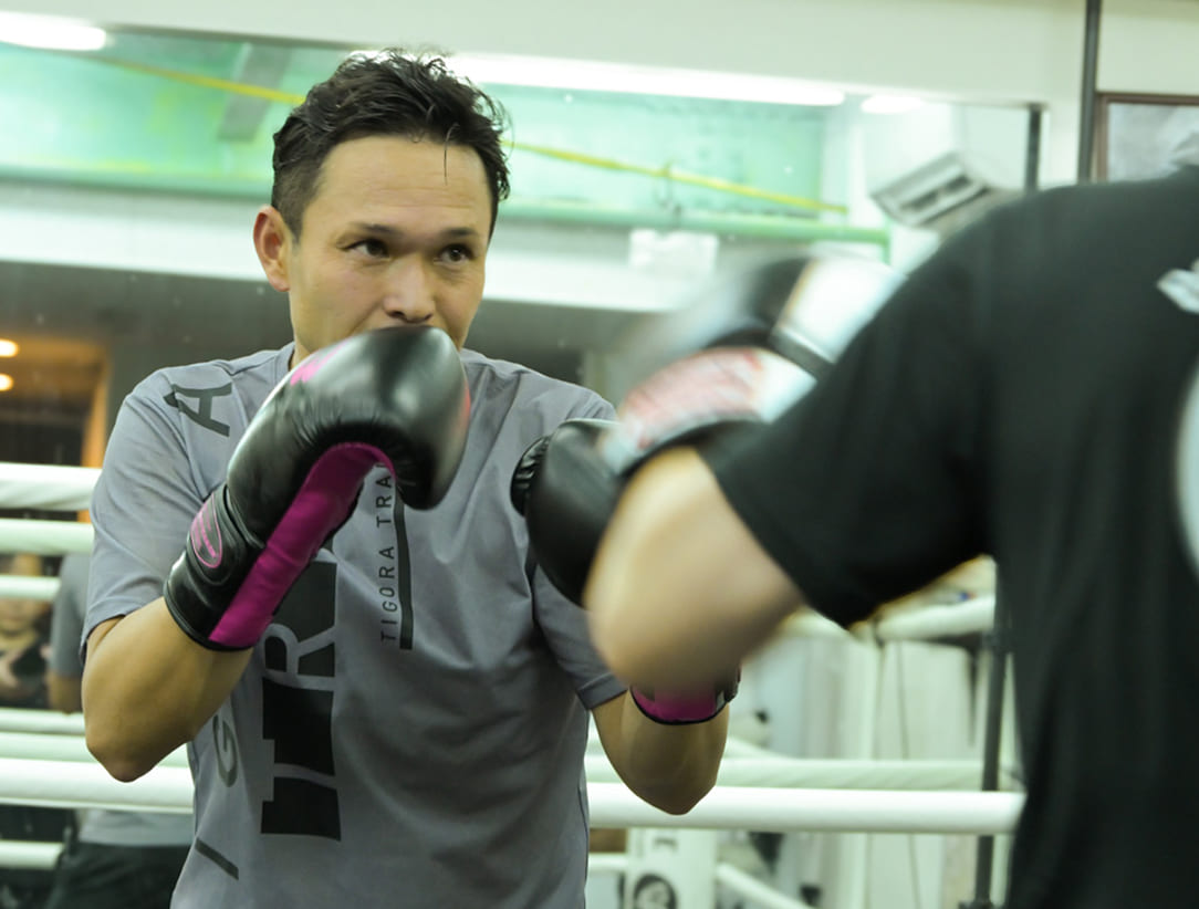 ジムで練習する会員とトレーナー